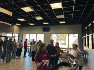 Math Instructor Daphne Perkins hands out water and pizza to students.