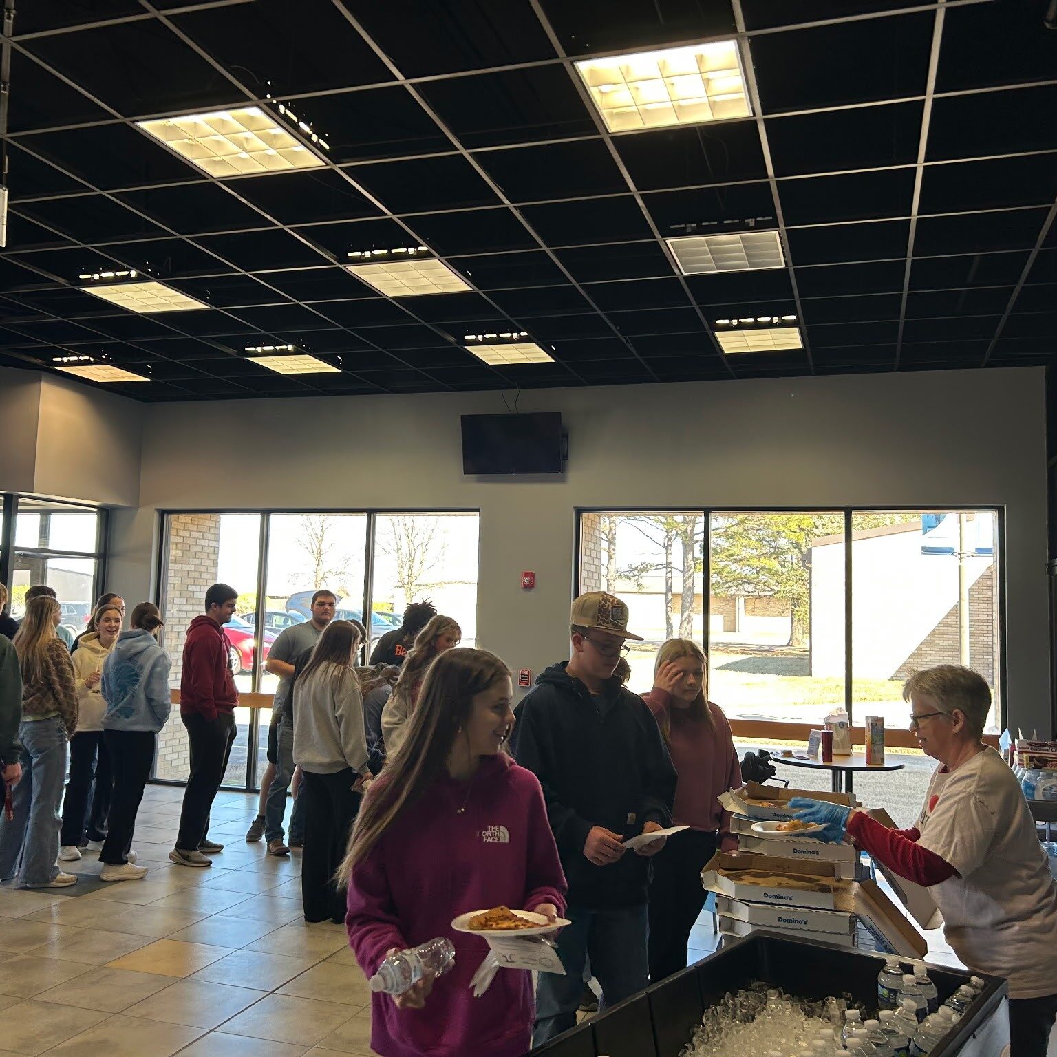 Math Instructor Daphne Perkins hands out water and pizza to students.